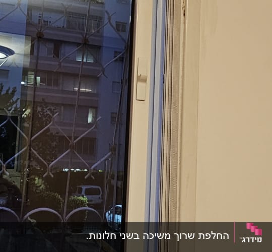 חלון עם תריסים סגורים ומסגרת לבנה